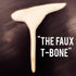 Close-up of a Faux T-Bone Mini Bulk wooden replica bone for plant-based meat dishes on a dark surface with text "THE FAUX T-BONE"